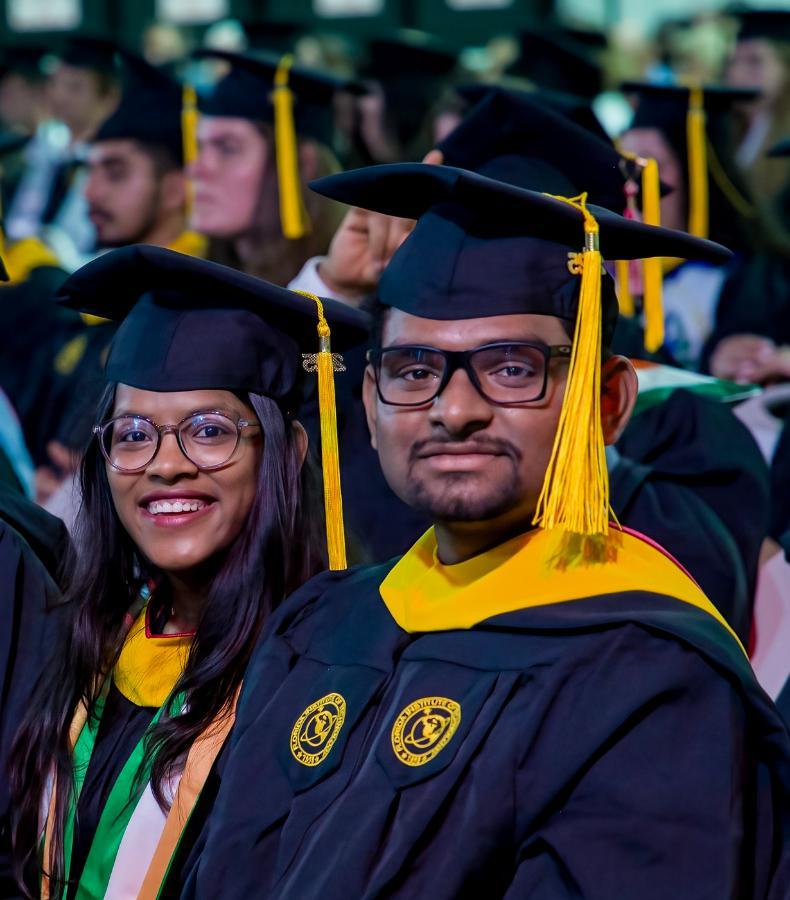 Two master's degree graduates at commencement