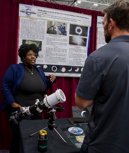 An astronomy and astrophysics student presents her capstone research at the senior design showcase.