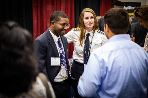 Representatives from multiple airlines speak with students at the aeronautics career fair.