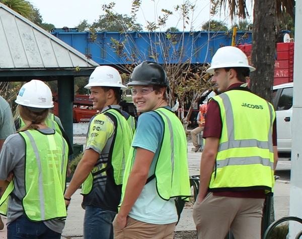 Students on a field trip to a bridge-building construction site