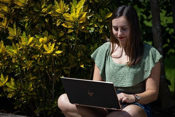 A student working on her computer outside