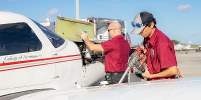 Two workers servicing a plane