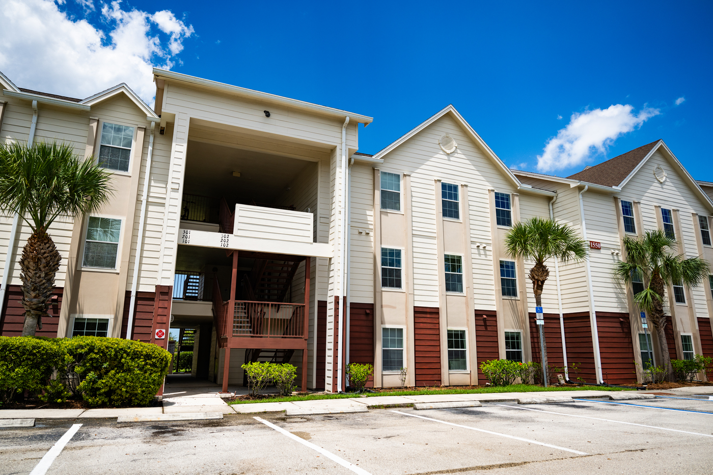 Panther Bay apartment building. A three-story apartment building on a sunny day with palm trees in front.